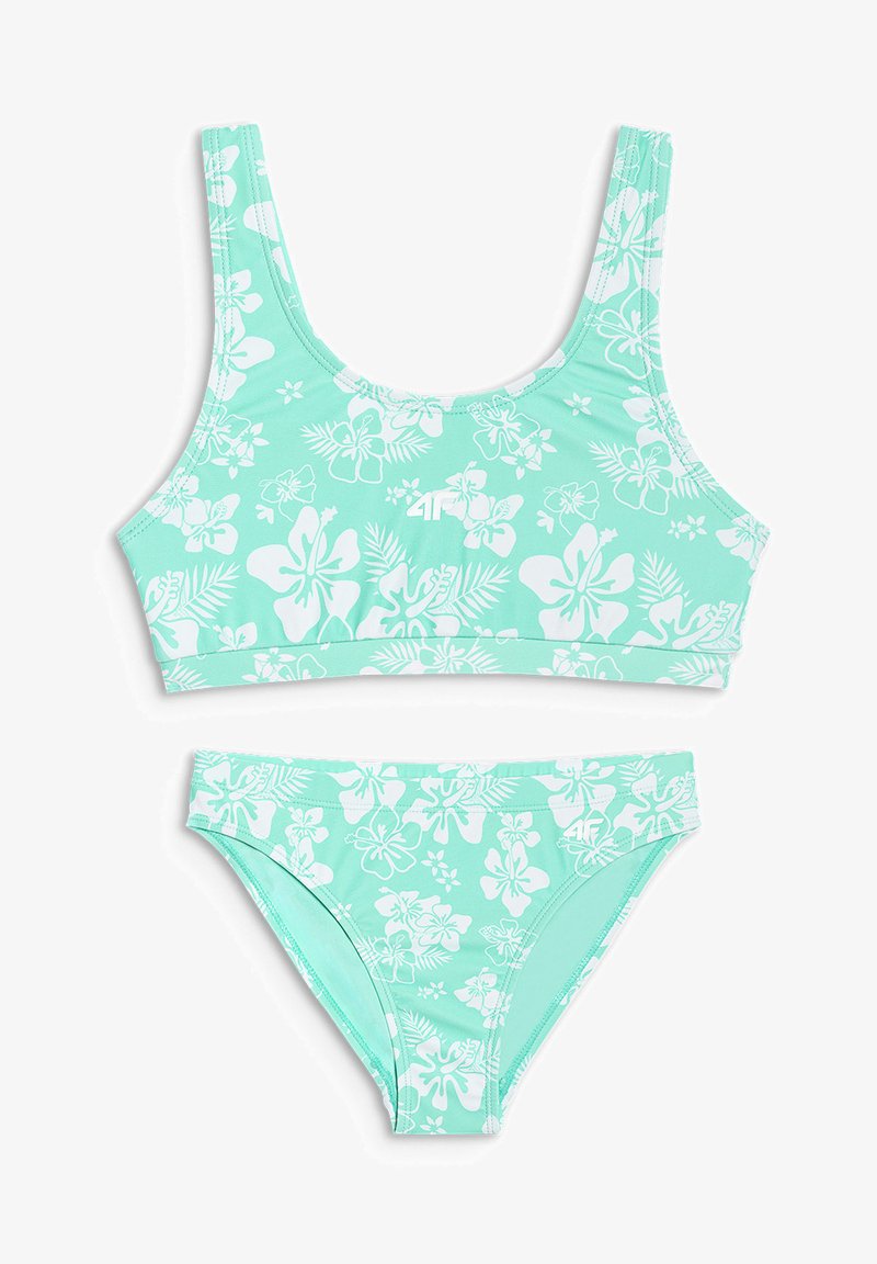 Maillot de bain deux pièces vert menthe avec motifs de fleurs et feuilles d’hibiscus blancs, comprenant un haut style brassière sportive et un bas de bikini assorti.