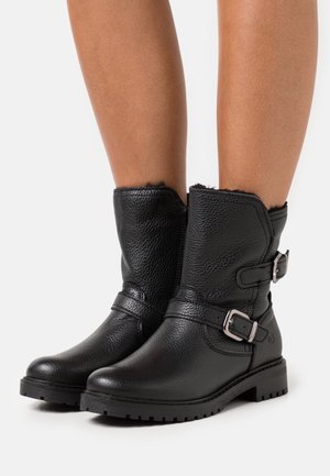 Botas de tobillo de cuero negro con un acabado texturizado, dos correas decorativas con hebillas y una suela robusta y texturizada.