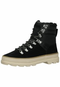 Botas de senderismo negras con parte superior de ante, ojales metálicos, cordones en contraste y una suela gruesa beis con detalles texturizados.