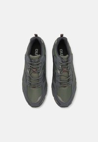 Grå og grønne sneakers med et teksturert design, mesh-paneler og brune detaljer. Har solide snører og en robust såle for holdbarhet.