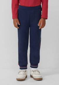 Navyblauwe sweatpants met een geribde tailleband en boorden. Bevat twee zijzakken en een klein grafisch detail op de dij.