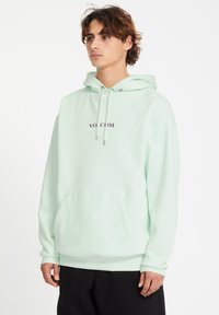 Mintgroene hoodie van zacht katoen met een voorste kangaroo zak, een trekkoordkap en geborduurde "VOLCOM" tekst in paars.