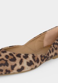 Πλατφόρμα παπουτσιού με καφέ και μαύρο μοτίβο λεοπάρδαλης και ταμπέ εσωτερικό, κεκλιμένο για να δείξει πλάγια και μερική άποψη από πάνω.