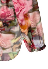 Floral-patterned blouse with pleated texture, featuring colors like pink, orange, and green. Includes a buttoned cuff detail.