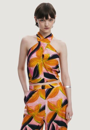 Top a fascia colorato e pantaloni abbinati, caratterizzati da un motivo floreale nei colori rosa, arancione e nero. Il tessuto sembra leggero con una texture morbida.