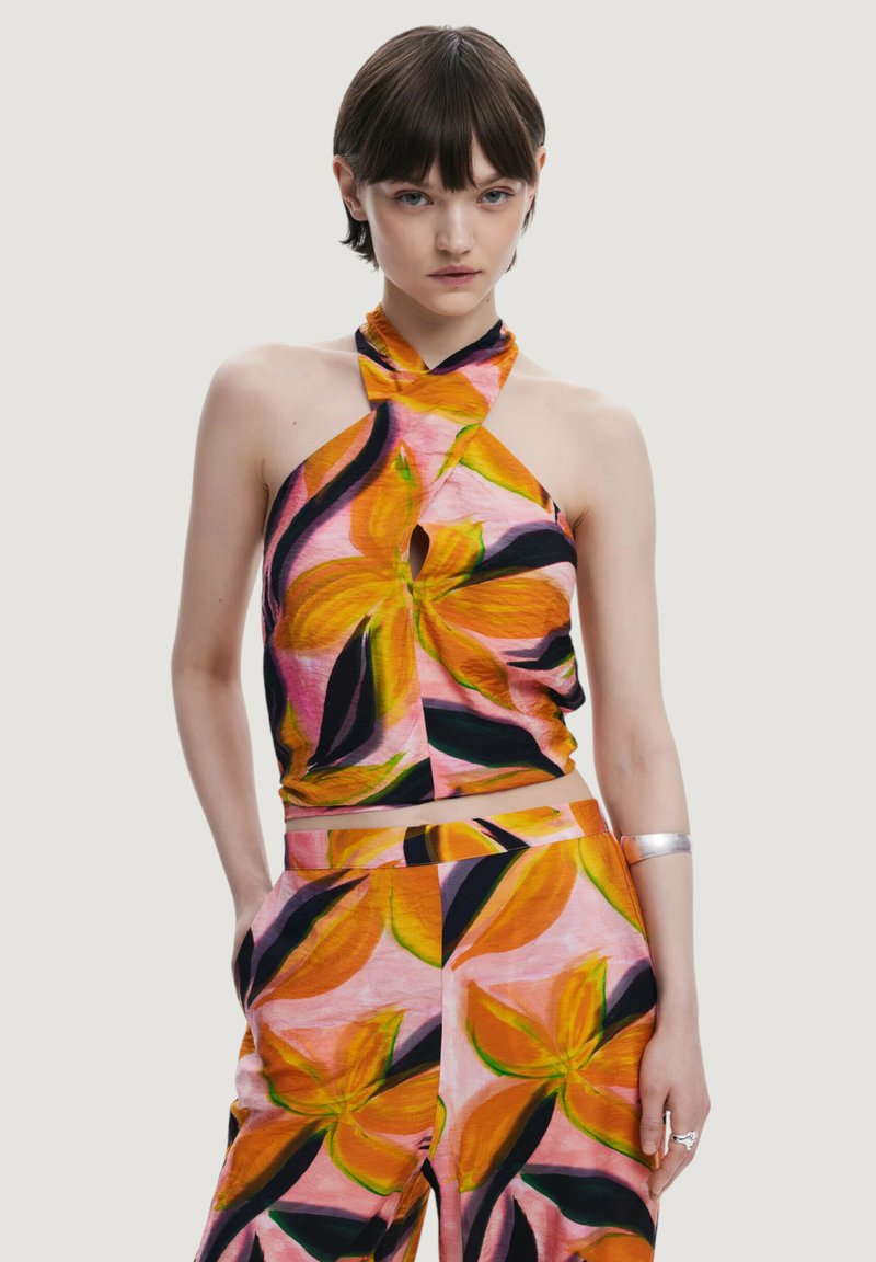 Top a fascia colorato e pantaloni abbinati, caratterizzati da un motivo floreale nei colori rosa, arancione e nero. Il tessuto sembra leggero con una texture morbida.