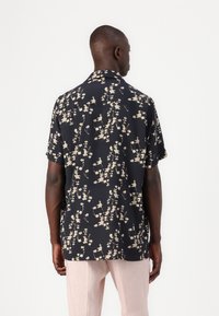 Short-sleeve, navy shirt with a white floral pattern, made from lightweight fabric, featuring a classic collar and relaxed fit.