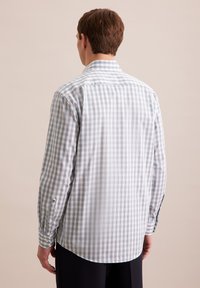 Camicia a maniche lunghe in un motivo a scacchi bianco e azzurro chiaro, con polsini a bottone e colletto classico, realizzata in tessuto intrecciato.