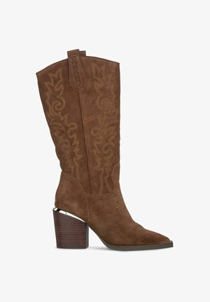 Botte de cowboy en daim marron avec des motifs floraux brodés, bout pointu et un solide talon en bois. Dotée d'une languette de tirage en haut.