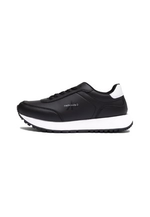 Czarne buty sportowe z gładką skórzaną cholewką, białą podeszwą środkową, czarną gumową podeszwą zewnętrzną i sznurowanym zapięciem. Logo marki po boku.