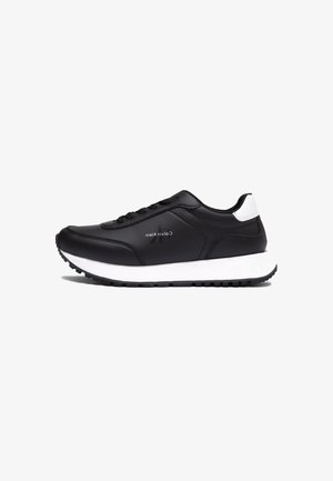 Czarne buty sportowe z gładką skórzaną cholewką, białą podeszwą środkową, czarną gumową podeszwą zewnętrzną i sznurowanym zapięciem. Logo marki po boku.