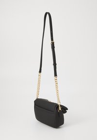 Black rectangular crossbody bag with gold chain accents and adjustable leather strap, photographed against a plain light background.