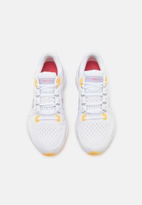 Scarpe sportive bianche con accenti rosa, dettagli gialli e tomaia in mesh ventilato. Presentano chiusura con lacci e suole imbottite. Modello: Vomero 16.