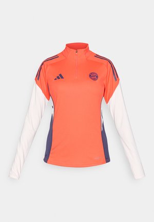 Long-sleeve athletic top featuring an orange body, white sleeves, purple accents, half-zip collar, and a logo on the chest.