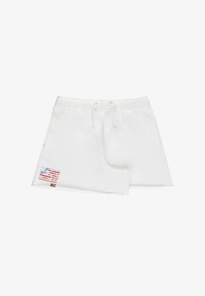 Gonna bianca asimmetrica con vita elasticizzata, coulisse, tasche laterali e una piccola toppa consumata con la bandiera americana vicino all'orlo.