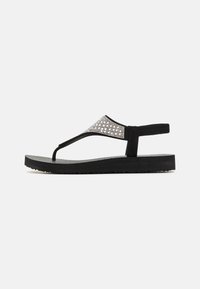 Svarte flip-flop sandaler med teksturert rem med sølvdetaljer, en polstret sort såle og en holdbar gummikonstruksjon.