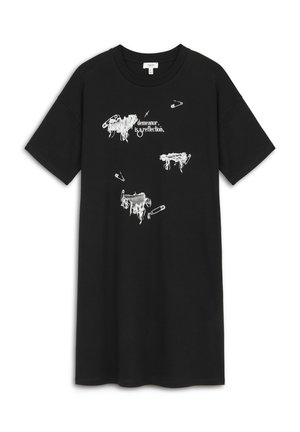 Camiseta de algodón negra con diseños abstractos en blanco de imperdibles y el texto "el comportamiento es un reflejo." Mangas cortas, cuello redondo.