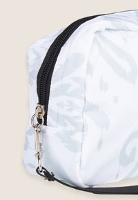 Borsa bianca con un sottile motivo grigio, con una cerniera nera e accessori in metallo argentato. Materiale testurizzato e forma arrotondata con un anello laterale.
