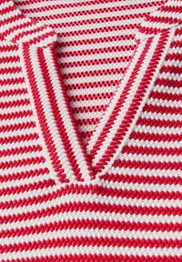 Rød- og hvidstribet striktop med V-udskæring og ribbet detaljering. Stoffet har et tekstureret, vævet udseende.