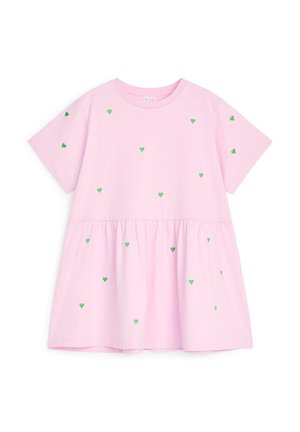 Lichtroze jurk met korte mouwen, een geplooide taille en verspreide kleine groene hartjespatronen op de voorkant en mouwen.