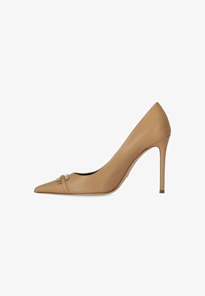 Décolleté beige con punta appuntita, tacco a spillo sottile e piccolo cinturino decorativo con fibbia dorata vicino alla punta.