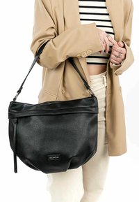 Black leather handbag with a soft texture, slouchy design, and a fold-over top. It features a silver hardware accent for the strap.
