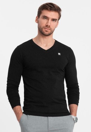 Czarna, długa koszulka z dekoltem w serek o dopasowanym kroju. Posiada małe logo na klatce piersiowej, wykonana z miękkiego, gładkiego materiału.