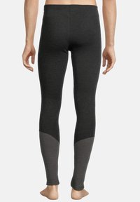 Leggings noirs au design ajusté, avec une accentuation grise claire sur le bas des jambes, fabriqués dans un tissu doux et texturé.