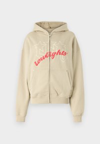 Beige zip-up hoodie made of soft fabric featuring a large embroidered "lowlights" text in pink, two front pockets, and a drawstring hood.