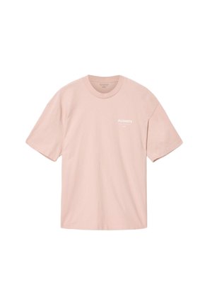Camiseta de algodón color rosa claro con mangas cortas, cuello redondo y logo de texto blanco en el área del pecho izquierdo. Textura suave, ajuste relajado.