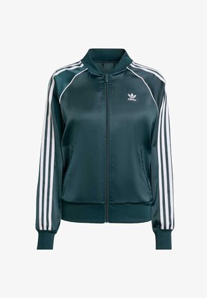 Ciemnozielona bomberka z satyny z białymi paskami na rękawach, ściągaczami na mankietach i u dołu oraz zapinana na zamek z przodu. Na piersi znajduje się logo.