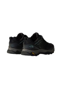 Pair of black North Face Gore-Tex hiking shoes with Vibram soles shown from back and angled side on white background.