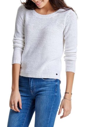 Pull en tricot blanc avec un col rond et des manches longues. La texture est en maille lâche et un petit logo noir est visible au niveau de l'ourlet.
