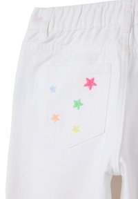 Witte spijkerbroeken met een elastische tailleband en een achterzak met kleurrijke geborduurde steraccenten in roze, blauw, groen, geel en oranje.