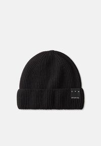 Black knit beanie with ribbed texture and a folded cuff, featuring a small branded tag on the side. Soft wool blend material.