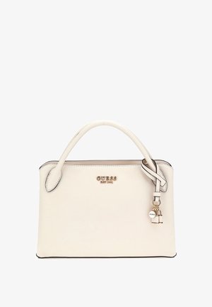 Bolso blanco con un acabado texturizado, herrajes en plata y un logo. Presenta un asa única y un detalle decorativo de charm.
