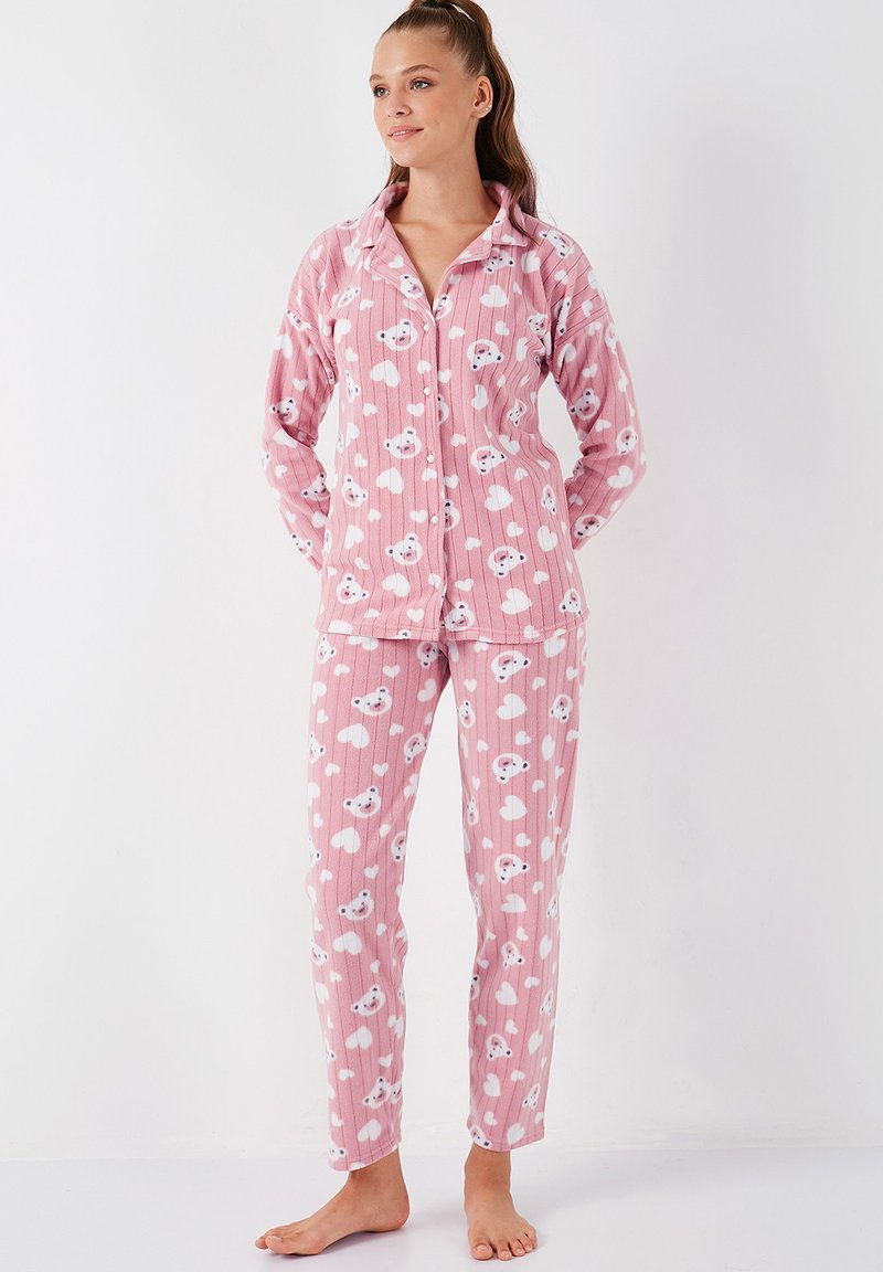 Set de pijamale roz, format dintr-o bluză cu nasturi și pantaloni asortați, împodobit cu un model de ursuleț de pluș și inimi, fabricat dintr-un material moale cu textură ribbed.