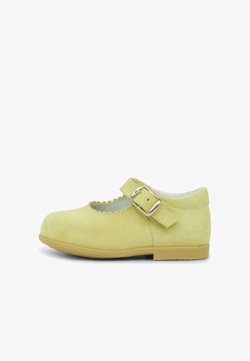 Chaussure Mary Jane en suède jaune avec bord festonné et bride à boucle ajustable. Design à semelle plate adapté aux enfants.