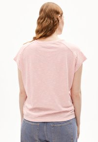 T-shirt à manches courtes rayé en rose pâle et blanc, avec une coupe décontractée et une texture douce. Le design comprend des manches raglan et un ourlet arrondi.