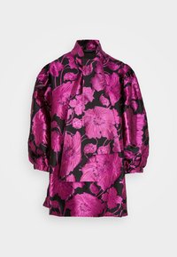 Svart blus med stor ljusrosa blommönster, puffiga trekvartslånga ärmar och en bred scarf-liknande krage.