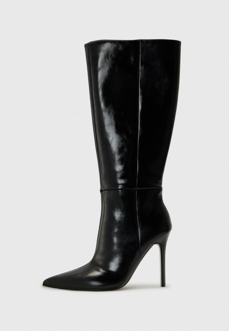 Bottes noires en cuir, hautes jusqu'au genou, avec un bout pointu et un talon aiguille haut. Texture lisse et design épuré, avec un minimum de détails.