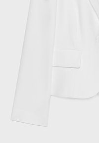 Manche de blazer blanche avec détail de poche à rabat assorti sur le devant, tissu lisse et finition nette et ajustée.