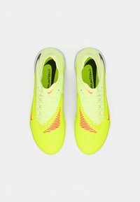 Zapatillas deportivas Nike Phantom de color amarillo brillante con acentos rojos, cordones blancos y logotipos de Nike negros visibles, vistas desde arriba sobre un fondo blanco.