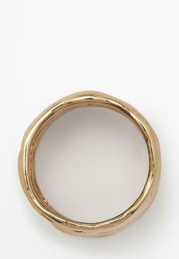 Gouden ring met een gladde, ronde band met een organisch, textuur oppervlak en onregelmatige randen voor een moderne, minimalistische uitstraling.