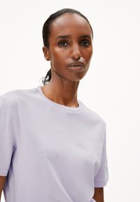 Lila, kurzärmliges T-Shirt aus weicher Baumwolle mit Rundhalsausschnitt und lässiger Passform, das eine glatte Textur und gleichmäßige Farbe zeigt.