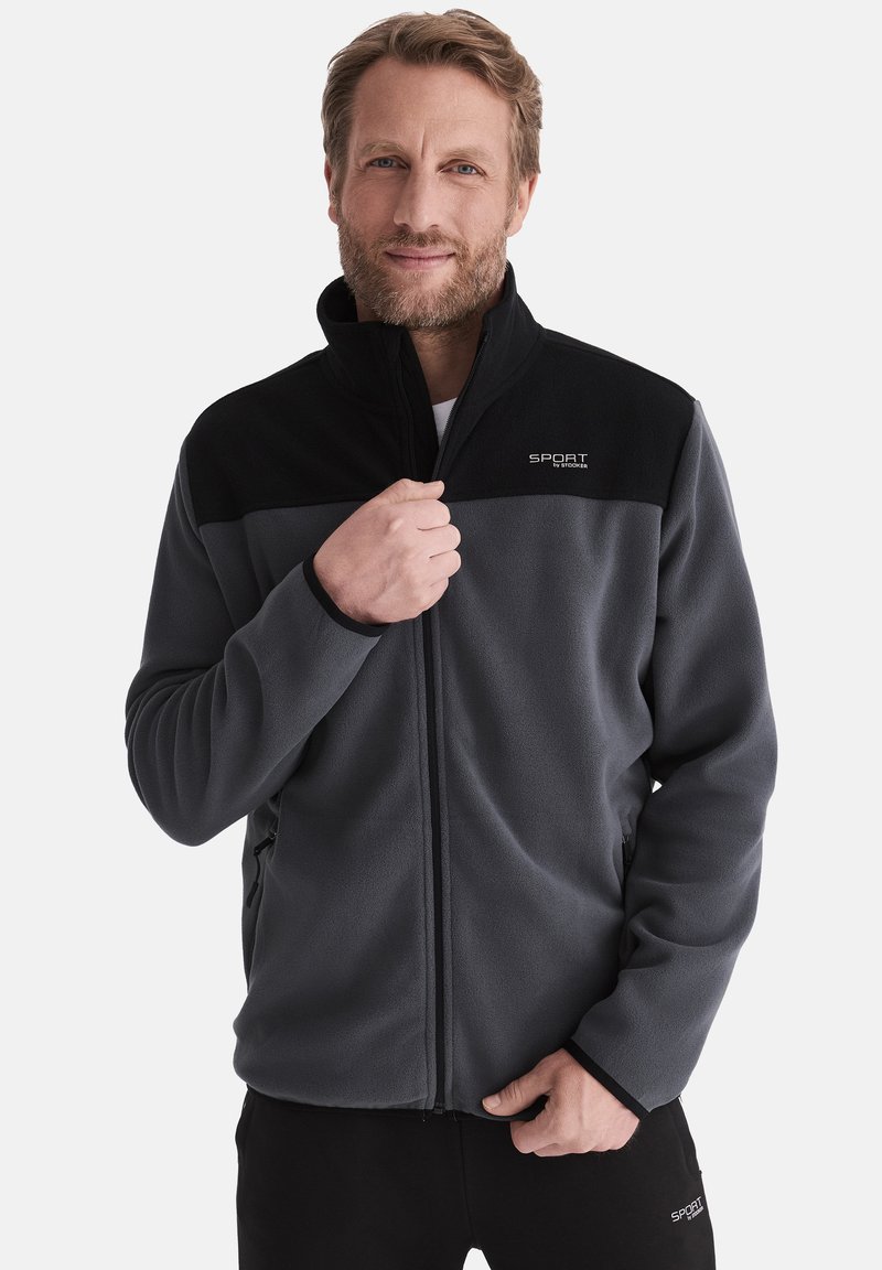 Fleecejacke in Grau mit schwarzen Akzenten, mit durchgehendem Reißverschluss, hohem Kragen und gesticktem Logo auf der Brust. Glatte Textur.