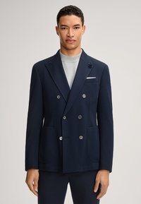 Marineblauwe dubbelgeknoopte blazer met visgraatpatroon, ingesneden revers, vier knopen, voorkantzakken en een decoratief bloemendetail op het revers.