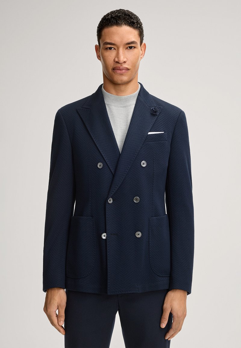 Marineblauwe dubbelgeknoopte blazer met visgraatpatroon, ingesneden revers, vier knopen, voorkantzakken en een decoratief bloemendetail op het revers.