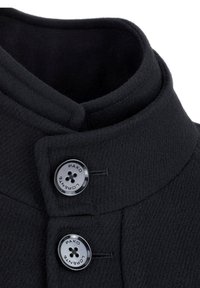 Czarny płaszcz wełniany z bliska, z wysokim kołnierzem, dwoma guzikami z wygrawerowaną nazwą marki oraz teksturowaną powierzchnią tkaniny.