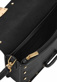 Sac à main en cuir noir avec quincaillerie dorée, présentant un extérieur lisse, un compartiment zippé et plusieurs emplacements pour cartes à l'intérieur.